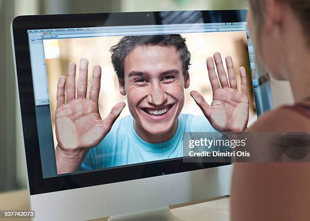 woman watching man's face against computer screen - two people video conferencing stock pictures, royalty-free photos & images