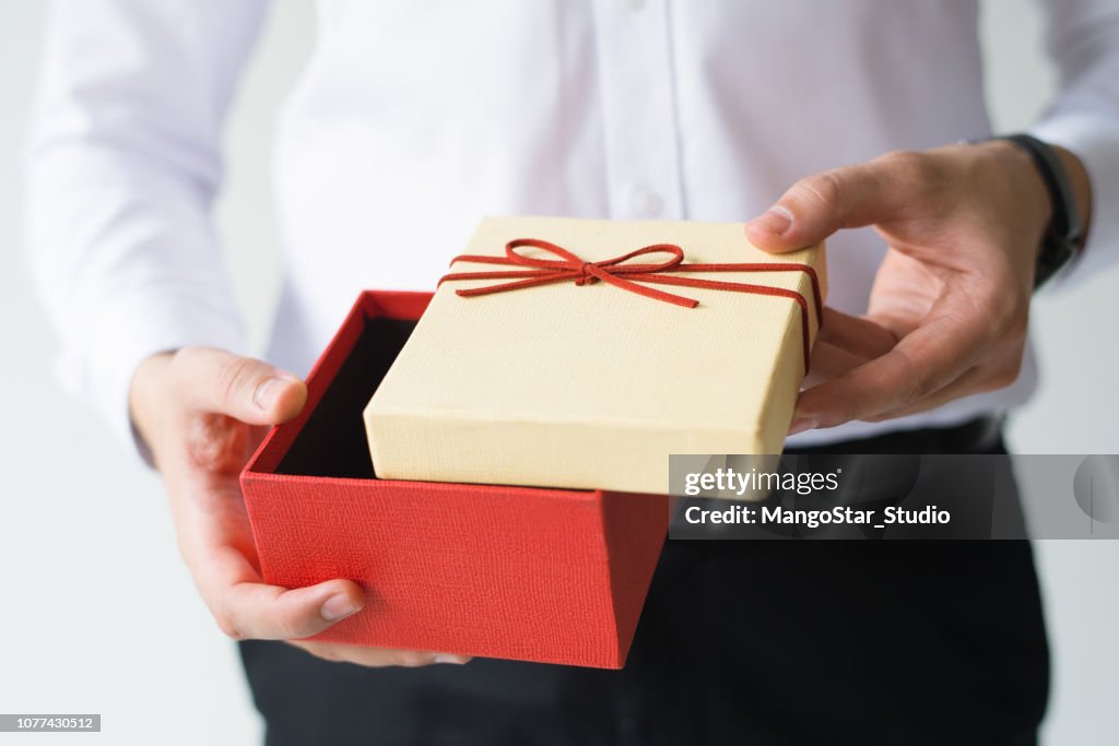 Closeup of business man opening gift box