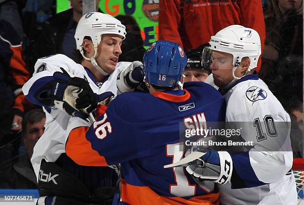 Vincent Lecavalier and Sean Bergenheim of the Tampa Bay Lightning confront Jon Sim at the Nassau Coliseum on December 22, 2010 in Uniondale, New...