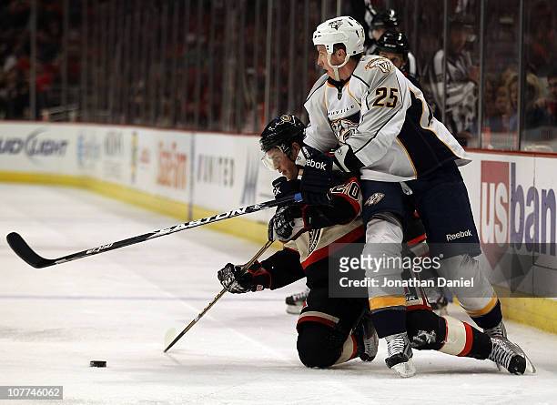 Jack Skille of the Chicago Blackhawks hits the ice after colliding with Jerred Smithson of the Nashville Predators as they battle for the puck at the...