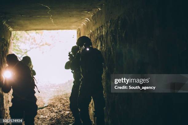 soldaten in dunklen höhle - militärisches trainingslager stock-fotos und bilder