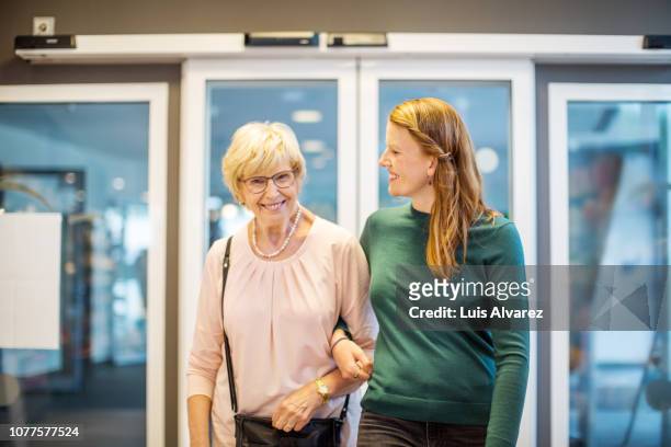 elder woman with daughter at pharmacy - arm in arm stock pictures, royalty-free photos & images