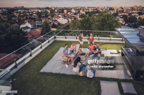 above view of happy friends having a party on a penthouse terrace. - women of penthouse stock pictures, royalty-free photos & images