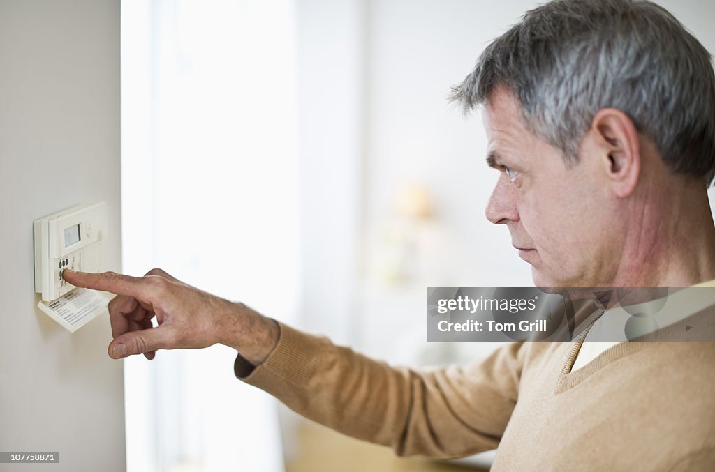 Man checking thermostat