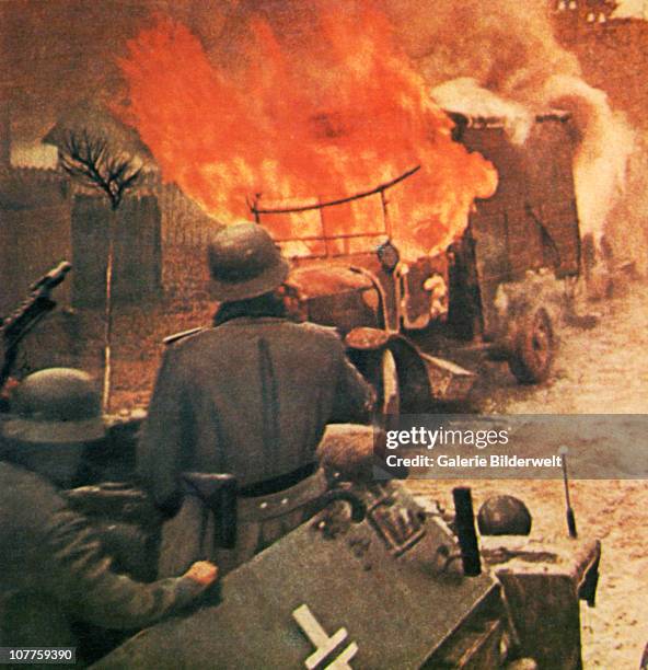 Operation Barbarossa, German soldiers in armoured vehicle of the Wehrmacht are approaching a burning Russian truck. 1943 They are part of over 4.5...