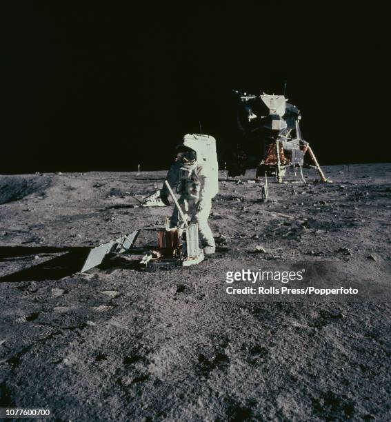 View of one of the Apollo 12 astronauts, either Commander Pete Conrad or Lunar Module pilot Alan Bean, setting up the Central Station of the ALSEP...