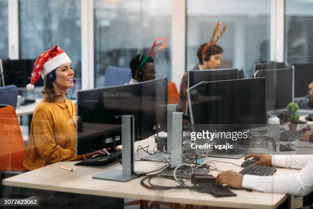 celebrating christmas in call center office. - christmas fun stock pictures, royalty-free photos & images