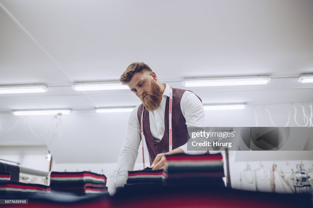 Bearded man working with textile