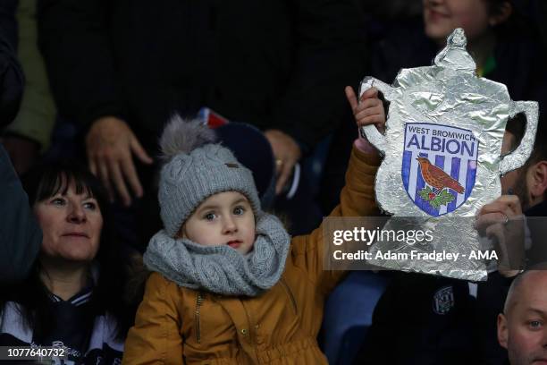 Young West Bromwich Albion Fan holds up a tinfoil / bacofoil cut out of the FA Cup during the FA Cup Third Round match between West Bromwich Albion v...