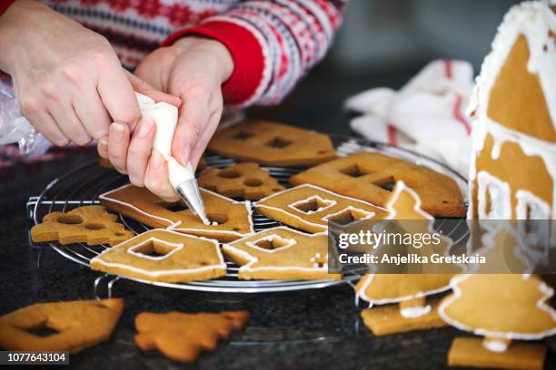 making christmas gingerbread house and cookies. - gingerbread cake stock pictures, royalty-free photos & images