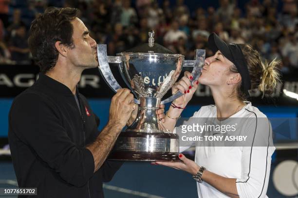 Roger Federer and his mixed doubles partner Belinda Bencic of Switzerland with the Hopman Cup after defeating runners-up Alexander Zverev and...