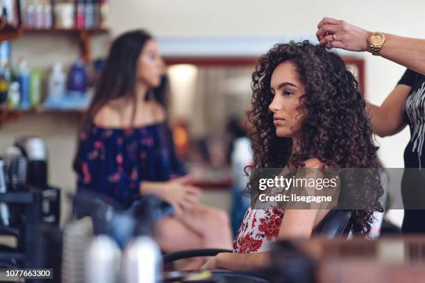 hispanic women in a hair salon - curly hair stock pictures, royalty-free photos & images