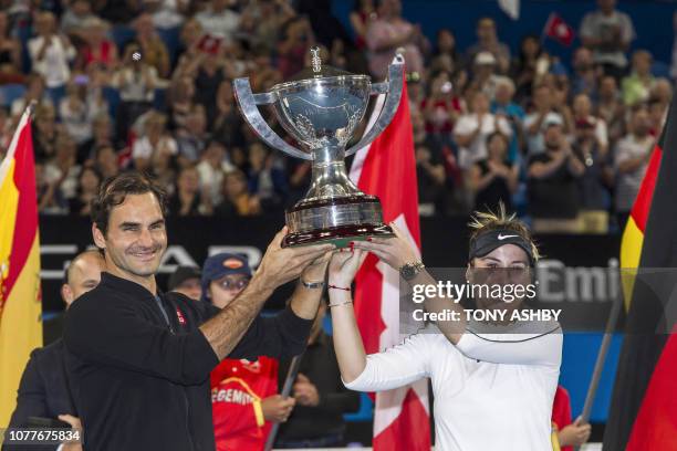 Roger Federer and his mixed doubles partner Belinda Bencic of Switzerland with the Hopman Cup after defeating runners-up Alexander Zverev and...