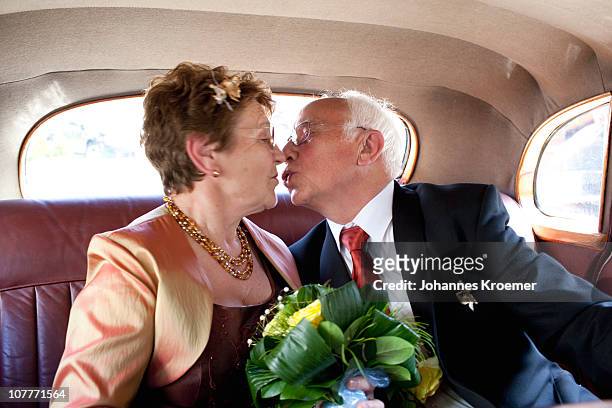 senior couple at their golden anniversary - auto küssen stock-fotos und bilder