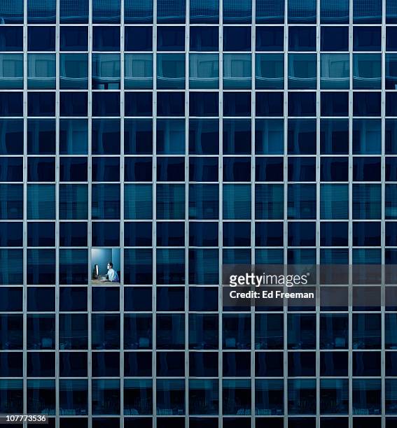hard at work after hours - skyscraper window stock pictures, royalty-free photos & images
