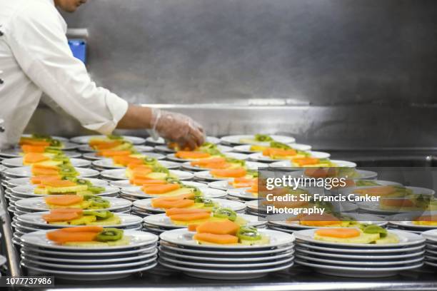 chef preparing 200 fruit salad portions as part of a fine dining restaurant menu - food and drink industry stock pictures, royalty-free photos & images