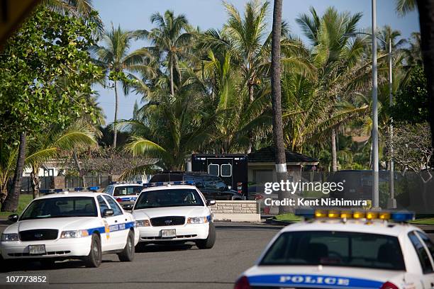 Honolulu Police Department vehicles stand by on the street as U.S. President Barack Obama's motorcade heads towards his vacation compound after...