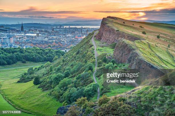 salisbury crags in holyrood park and downtown edinburgh scotland - edinburgh scotland stock pictures, royalty-free photos & images