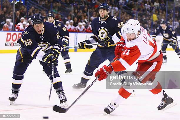 Daniel Cleary of the Detroit Red Wings shoots the puck against B.J. Crombeen of the St. Louis Blues at the Scottrade Center on December 23, 2010 in...