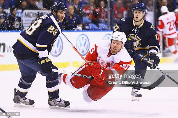 Johan Franzen of the Detroit Red Wings shoots the puck against Carlo Colaiacovo and Vladimir Sobotka both of the St. Louis Blues at the Scottrade...