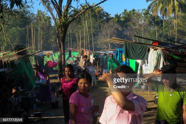 People, displaced by violence between ethnic Rakhine rebels and Myanmar's army, gather at a makeshift camp in Kyauktaw, Rakhine state, on January 5,...