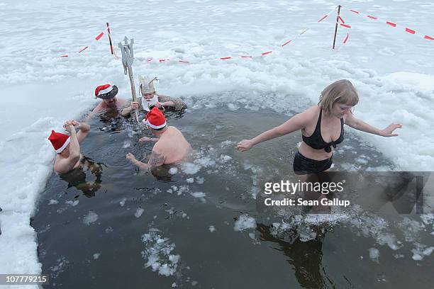 Members of the Berlin Seals swimming club take a dip in icy Orankesee lake during their traditional Christmas Day ice swim on December 25, 2010 in...