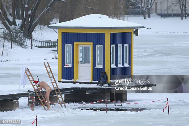 Member of the Berlin Seals swimming club takes a dip in icy Orankesee lake during the club's traditional Christmas Day ice swim on December 25, 2010...