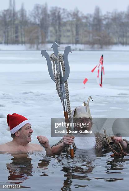 Members of the Berlin Seals swimming club, including one dressed as Neptune, take a dip in icy Orankesee lake during their traditional Christmas Day...