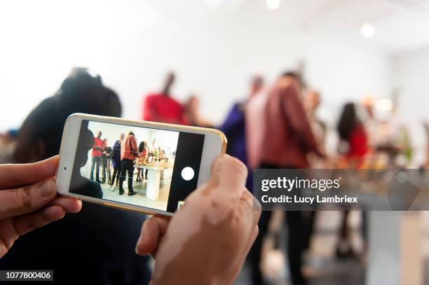 young man taking pictures at a creative pop up store - pop up store stock pictures, royalty-free photos & images