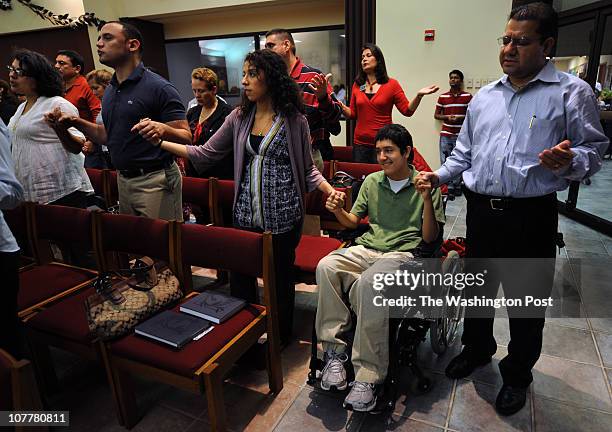 Luis Jovel also known as Junior, prays with his family at Saint John Neumann Catholic Church. Left to right: Mother Norma, brother Juan, sister...