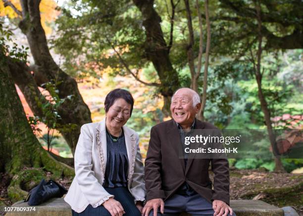 happy senior couple taking a break in forest - japonês imagens e fotografias de stock