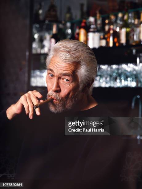 Actor James Coburn at age 63 enjoys a cigar January 1, 1991 in his Sherman Oaks home, California