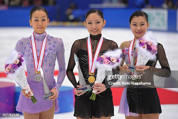 Mao Asada, Miki Ando and Kanako Murakami pose for photographs on the podium at the medal ceremony during the All Japan Figure Skating Championships...