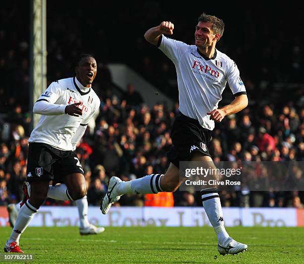 Aaron Hughes of Fulham celebrates with Dickson Etuhu as he scores their first goal with a header during the Barclays Premier League match between...