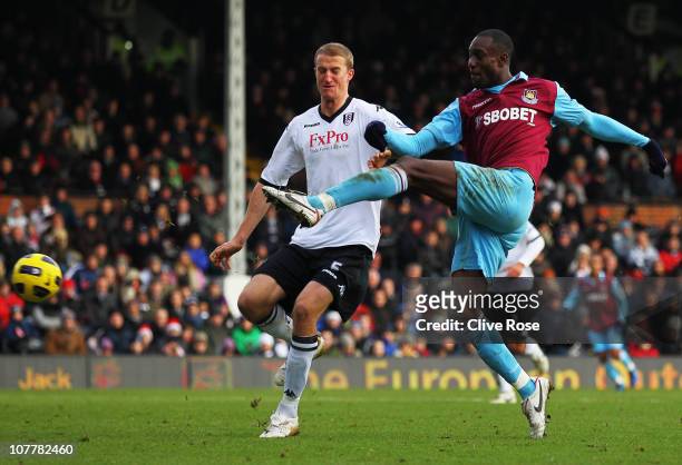 Carlton Cole of West Ham United beats Brede Hangeland of Fulham to score their third goal during the Barclays Premier League match between Fulham and...