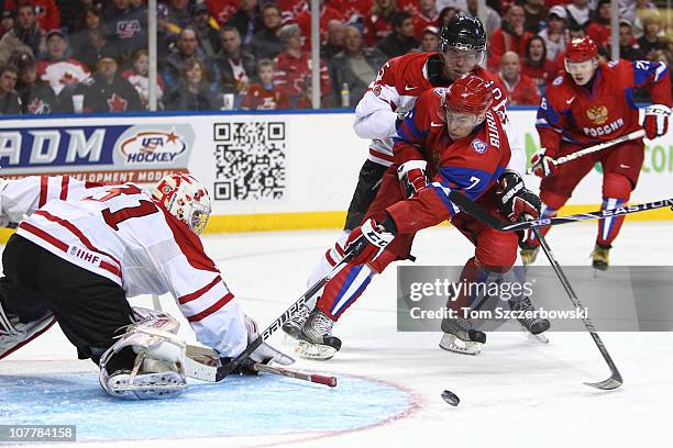 Anton Burdasov of Russia is upended by Erik Gudbranson of Canada during the 2011 IIHF World U20 Championship Group B game between Canada and Russia...