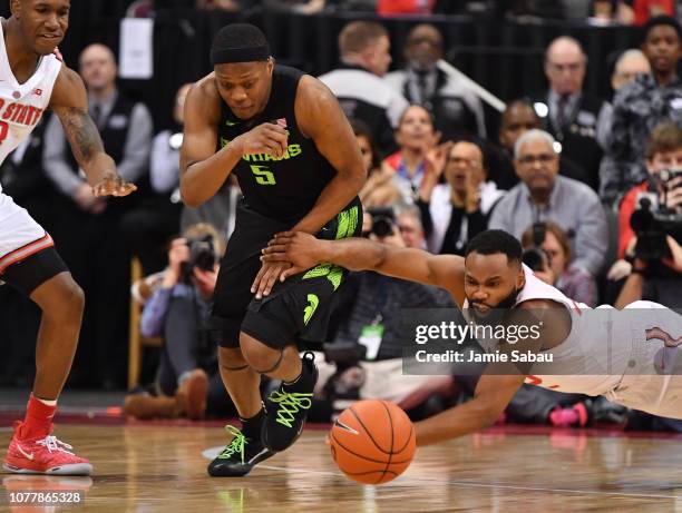 Cassius Winston of the Michigan State Spartans outruns a diving Keyshawn Woods of the Ohio State Buckeyes to a loose ball in the second half on...