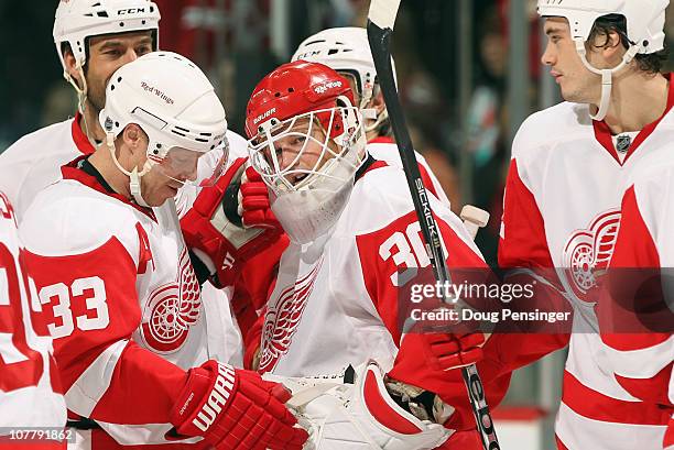 Goalie Chris Osgood of the Detroit Red Wings is congratulated by Kris Draper and his teammates after he earned his 400th win with a victory over the...