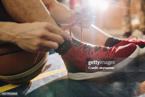 cerca de atar los cordones en cancha de baloncesto. - basketball shoe fotografías e imágenes de stock