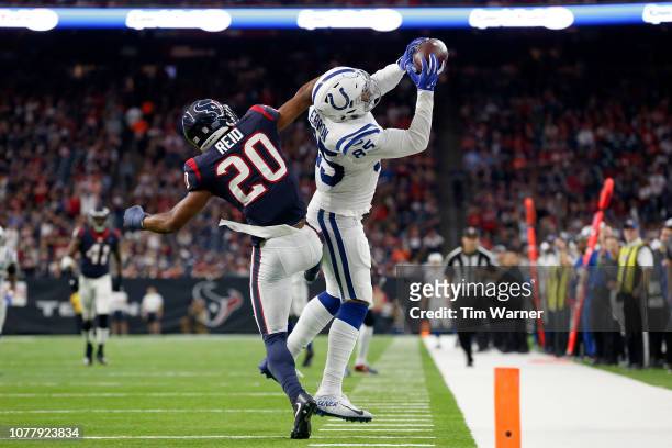 Eric Ebron of the Indianapolis Colts catches a pass in the second quarter defended by Justin Reid of the Houston Texans during the Wild Card Round at...