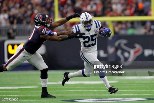 Marlon Mack of the Indianapolis Colts runs the ball in the second quarter defended by Zach Cunningham of the Houston Texans during the Wild Card...