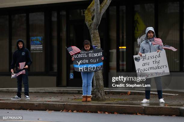 Mourners hold signs during the funeral procession for slain Newman police officer Corporal Ronil Singh on January 5, 2019 in Modesto, California....