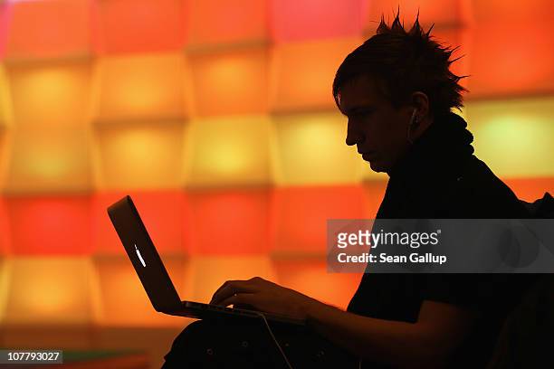 Participant sits with a laptop computer as he attends the annual Chaos Communication Congress of the Chaos Computer Club at the Berlin Congress...