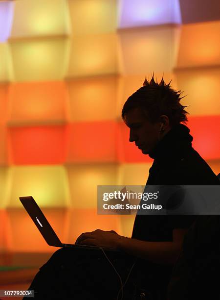 Participant sits with a laptop computer as he attends the annual Chaos Communication Congress of the Chaos Computer Club at the Berlin Congress...