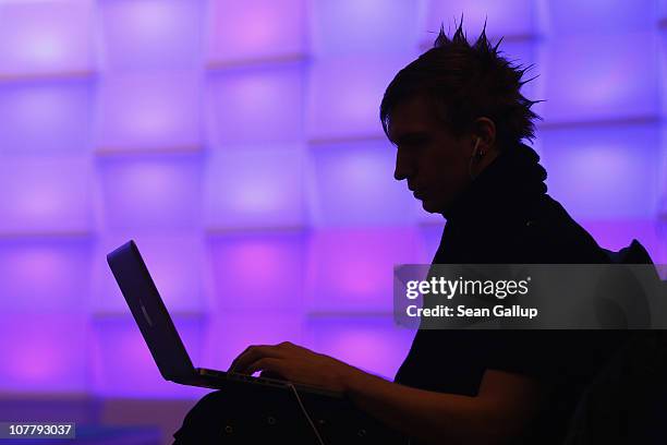 Participant sits with a laptop computer as he attends the annual Chaos Communication Congress of the Chaos Computer Club at the Berlin Congress...