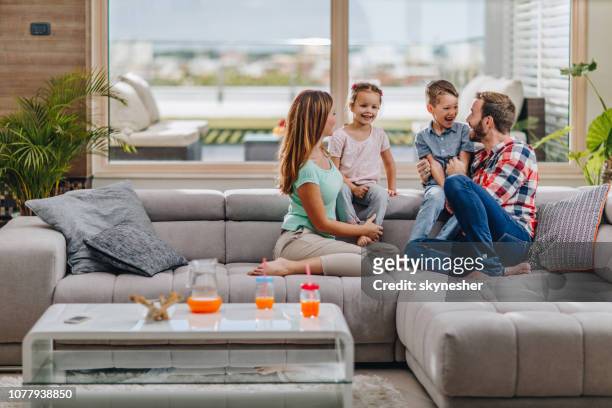 young happy family talking in the living room. - penthouse girl stock pictures, royalty-free photos & images