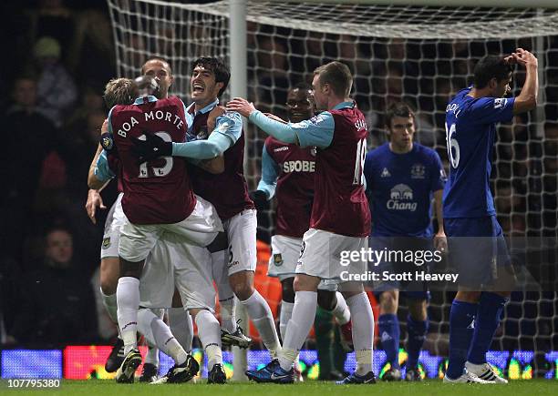 James Tomkins of West Ham United and team mates celebrate the own goal by Tony Hibbert of Everton during the Barclays Premier League match between...