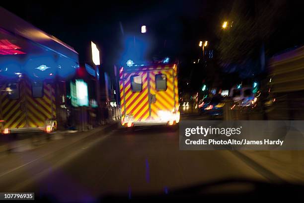 ambulance driving on street at night - ambulance bildbanksfoton och bilder