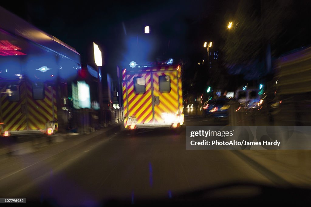 Ambulance driving on street at night