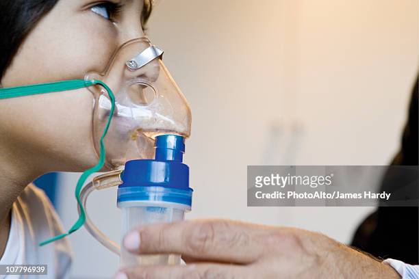 boy receiving oxygen treatment - oxygen mask stock pictures, royalty-free photos & images
